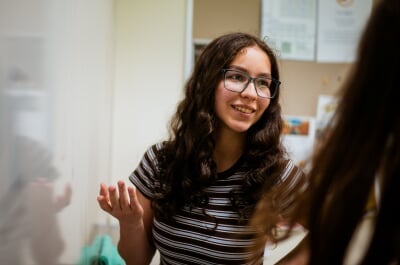 Student Diana Shadibaeva standing at a whiteboard.