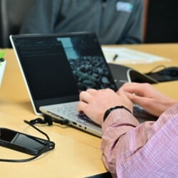 Student typing code on a laptop.
