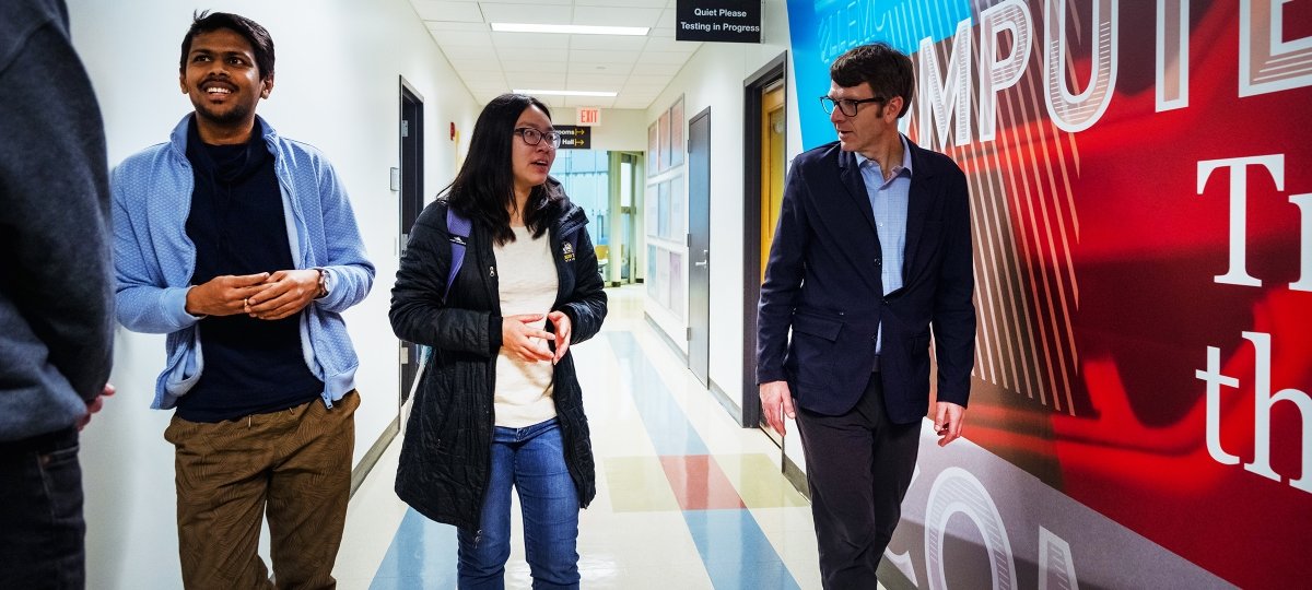 Dean Dennis Livesay talks with students Rekhi Hall, 2nd floor hallway.