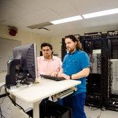 Two researchers standing at a computer in server lab