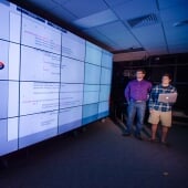 Two researchers standing next to a large screen