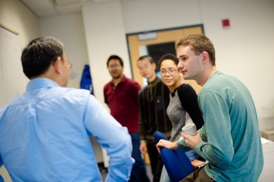 faculty and students standing, talking