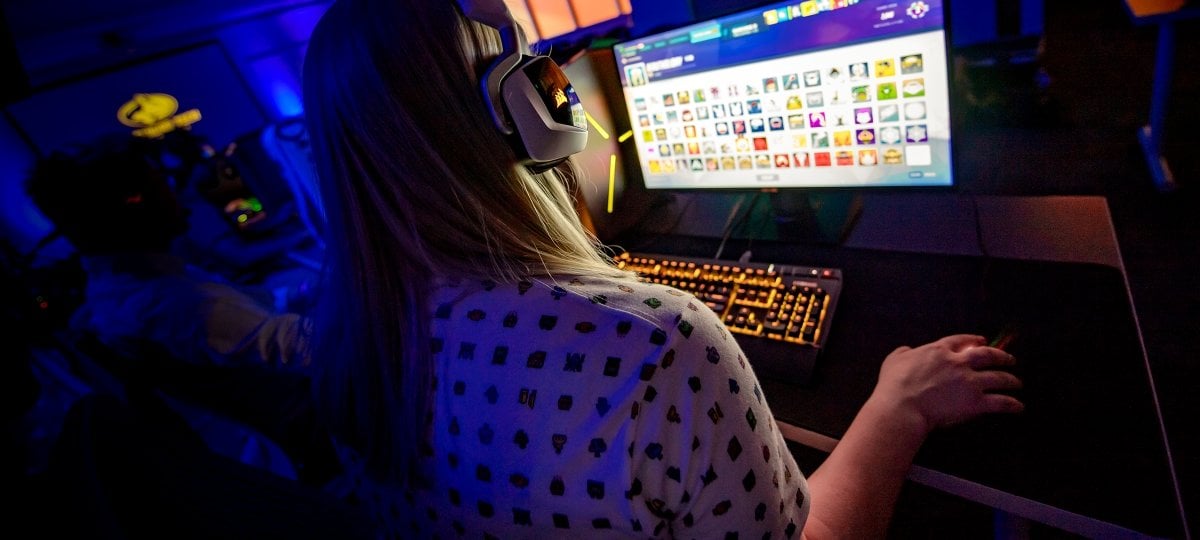 Student in earphones in front of a colorful computer screen