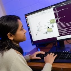 Student typing on a computer.