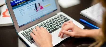 Hands typing on a laptop.