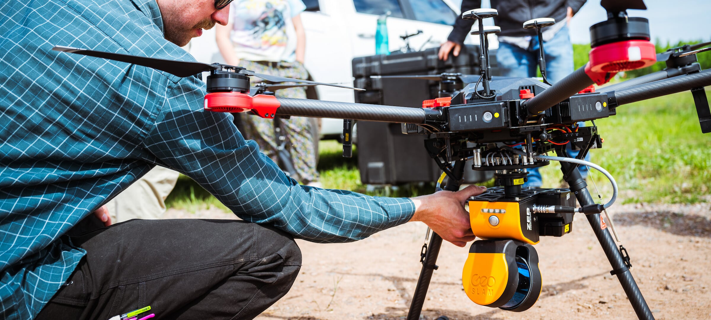 A student prepares a drone with environmental sensing equipment for flight.