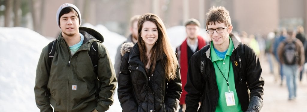 Eight students sitting on campus.