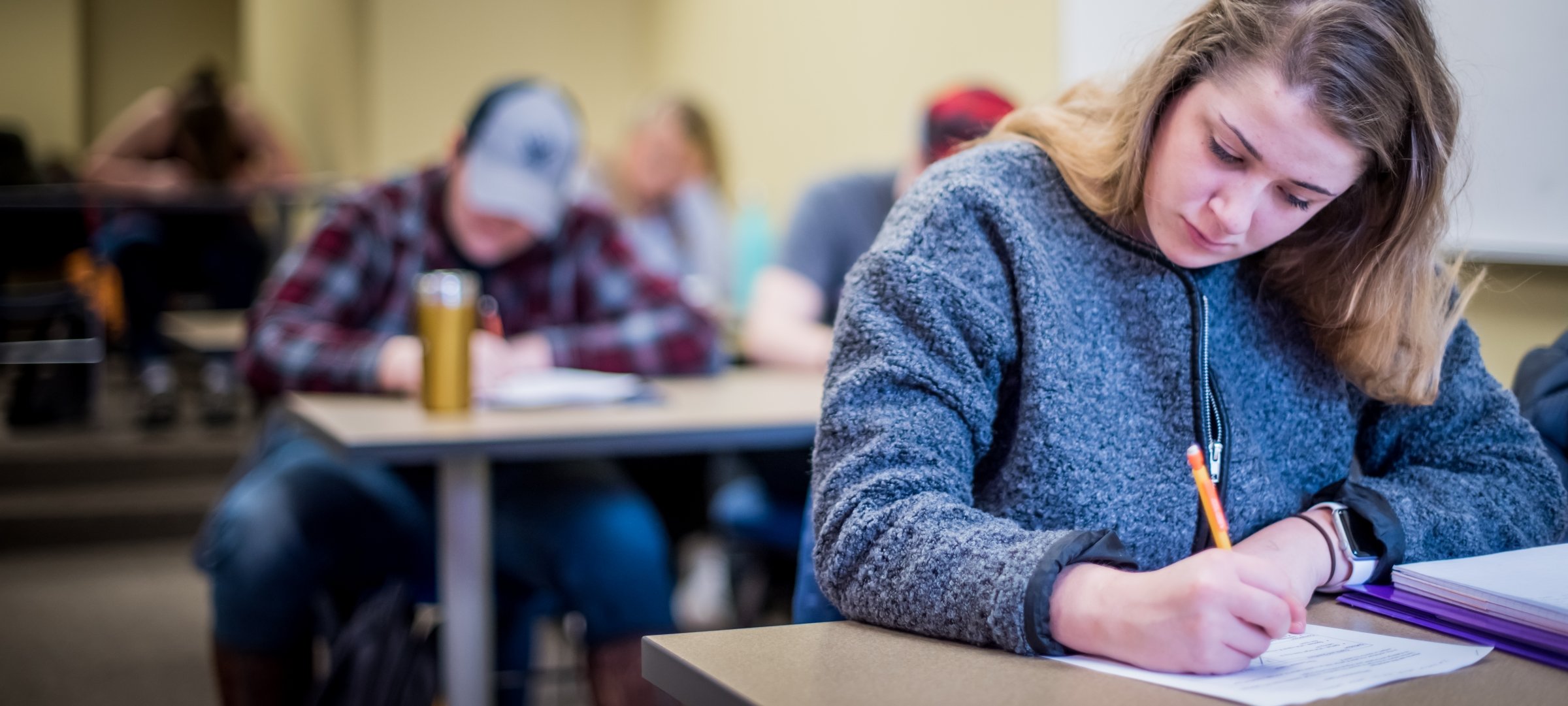 Students in a classroom taking an exam.