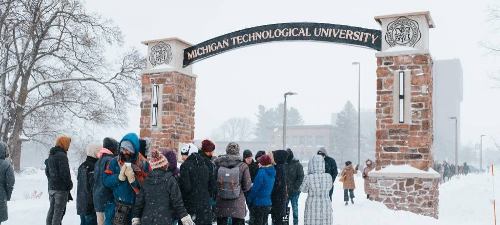Students by Michigan Tech arch