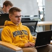 Student sitting in the Library with laptop