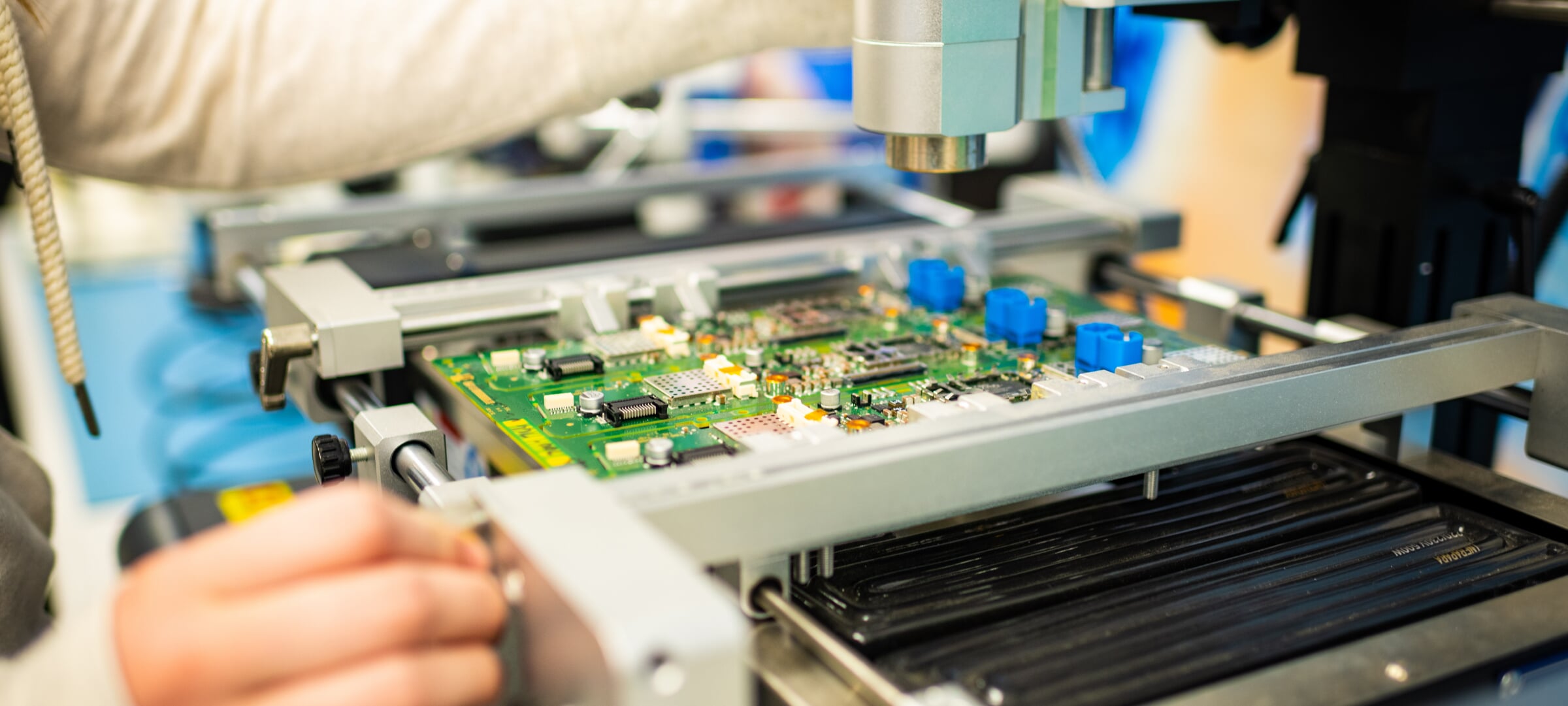 A close up of a circuit board under a machine to look at it closer