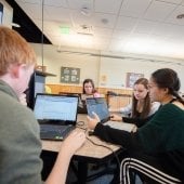 Engineering students in a classroom on laptops.