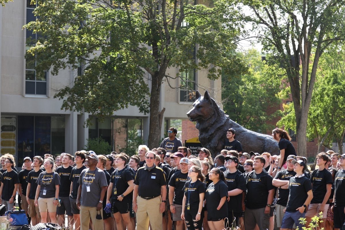 Large group standing by the Husky Statue.