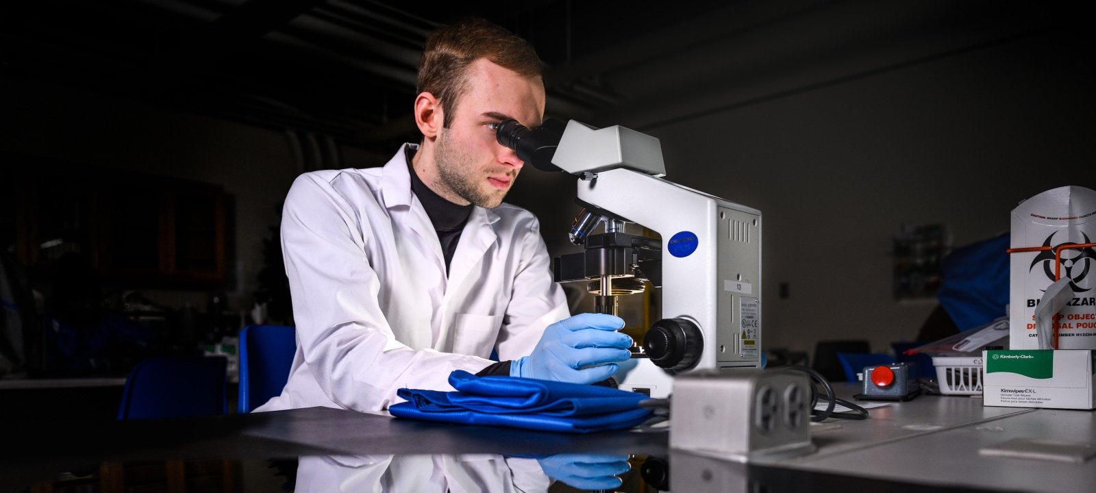 Student in a medical lab using a microscope.