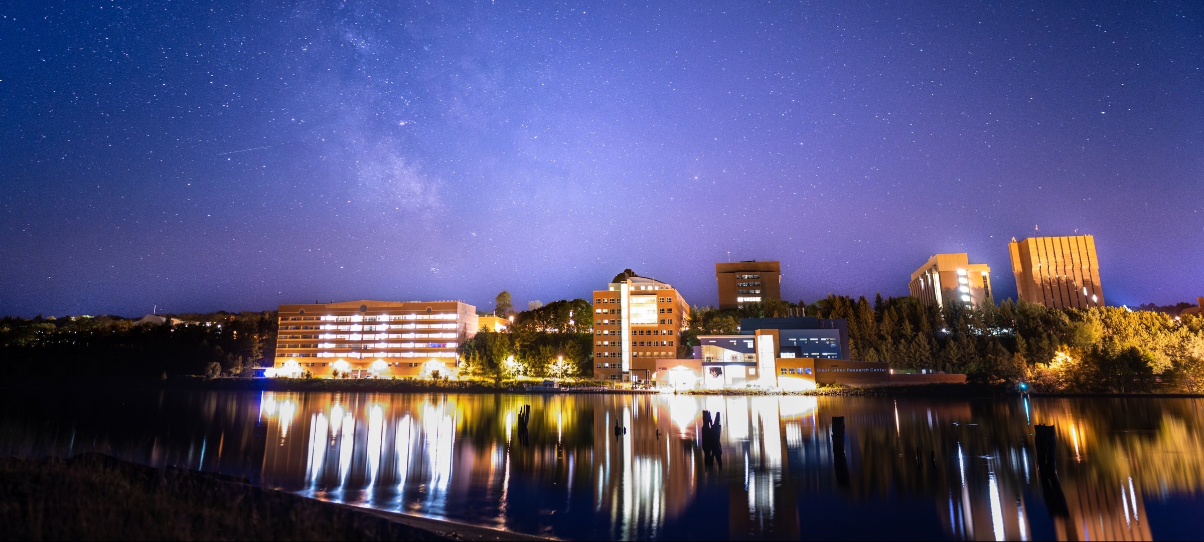 View of Michigan Tech campus and Portage Canal at night with the Milky Way.