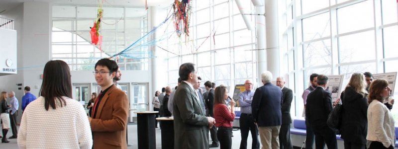 People mingle at the Mobility Summit poster session.