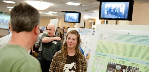 Undergraduate engineering student giving a poster presentation.