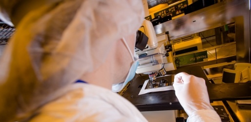 Engineering student looking through a microscope.