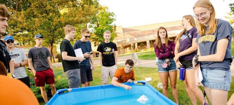 Students experimenting with foam boats during orientation.