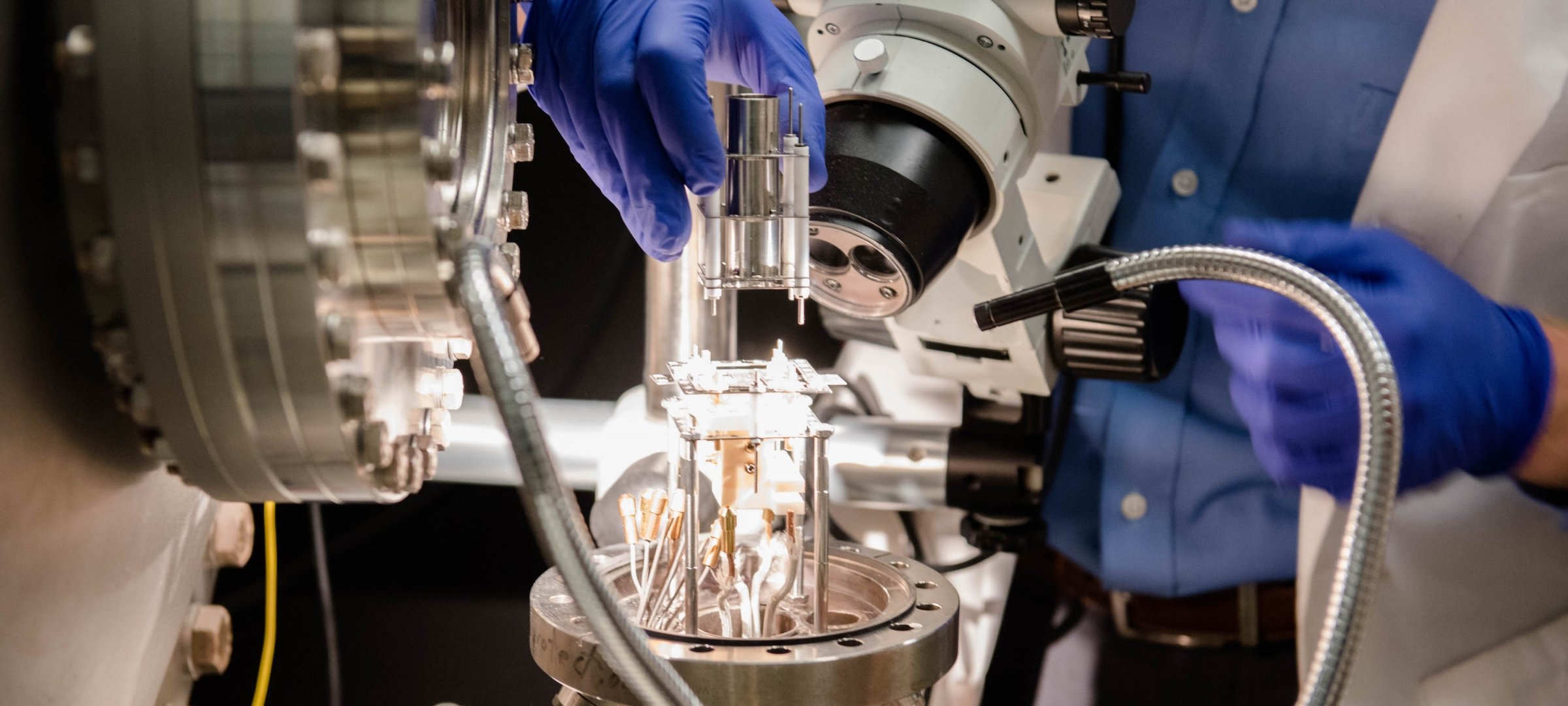 Researchers in clean suits working in a lab.