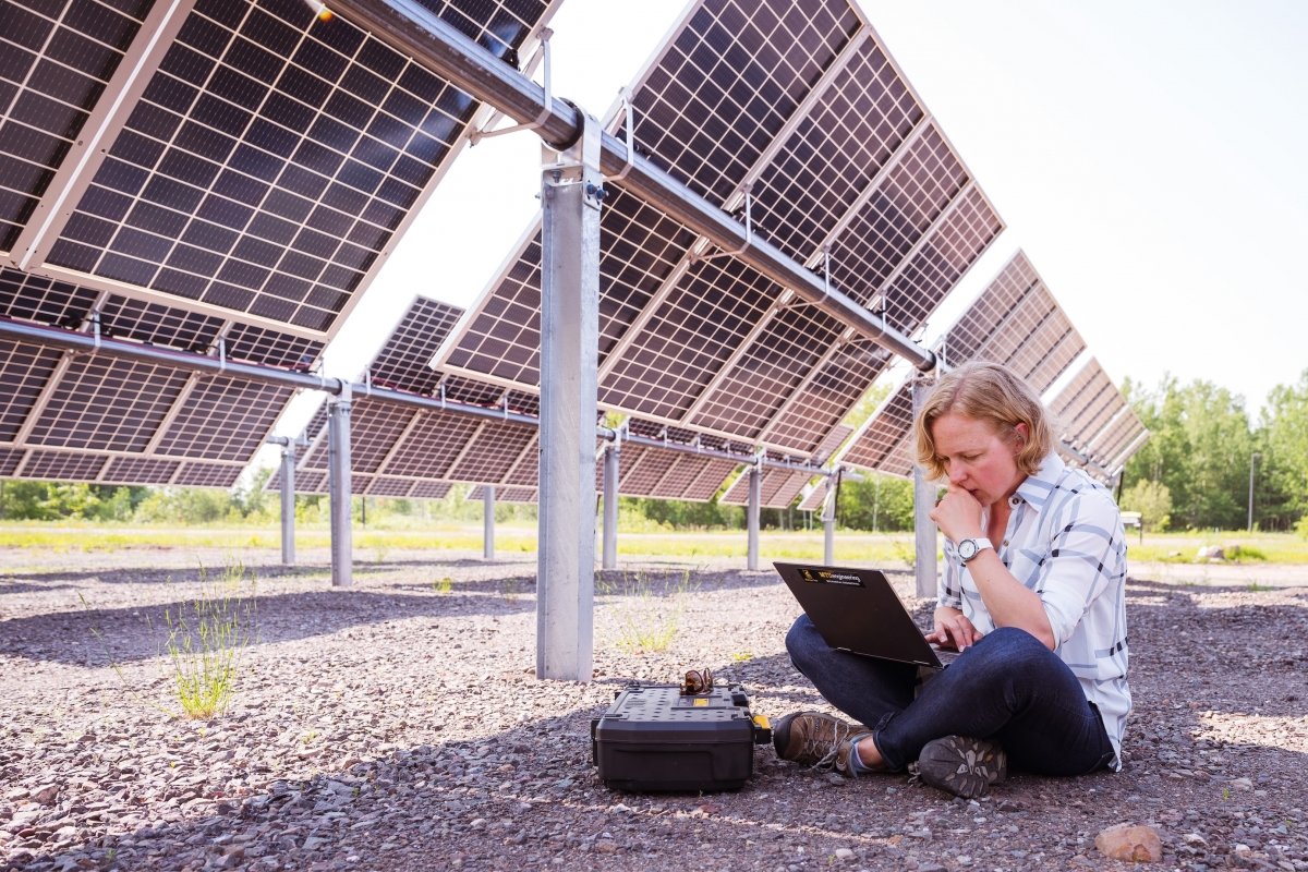 Ana Dyreson seated by solar panels.