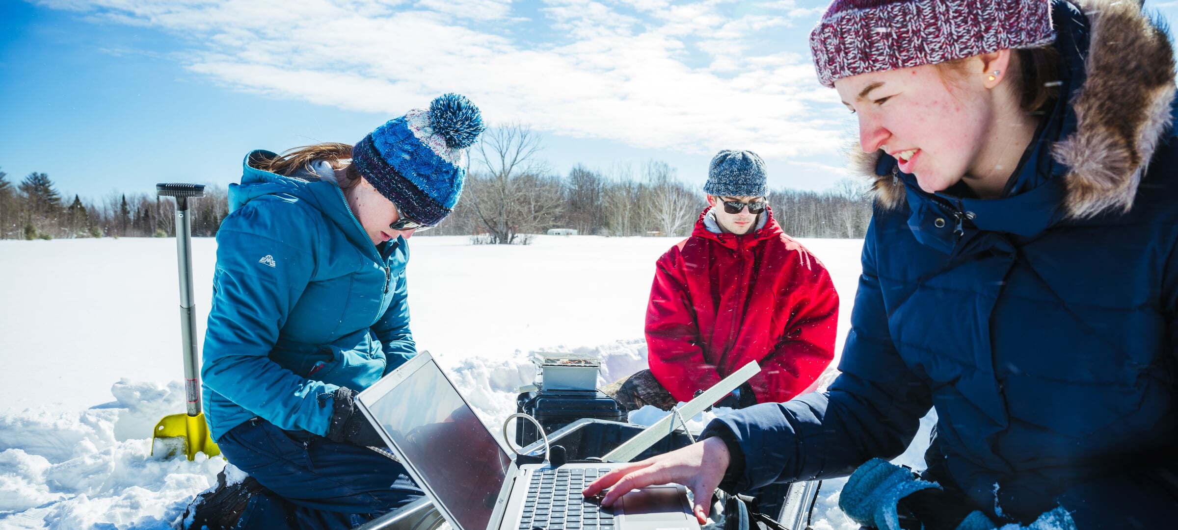 Students using a laptop in the snow
