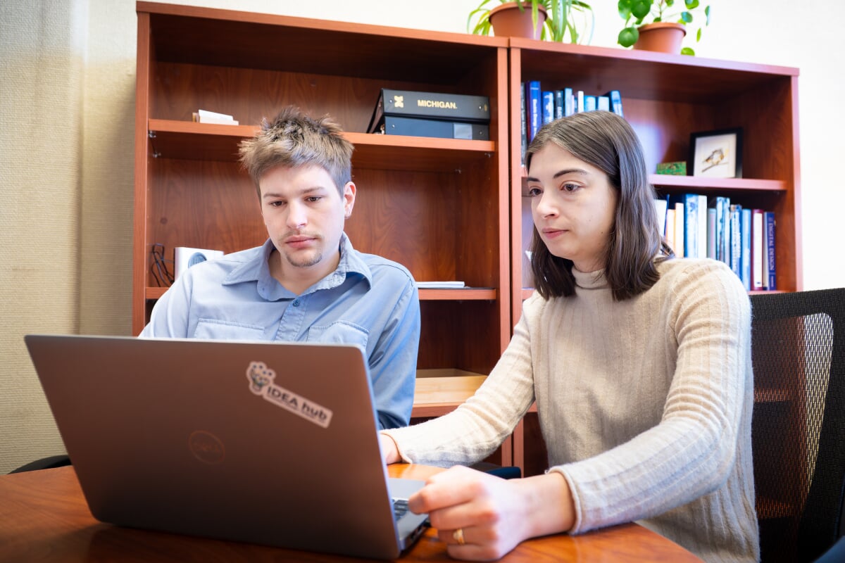 Two students looking at a laptop