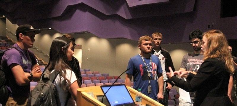 First-year engineering students approaching the speaker at the podium.