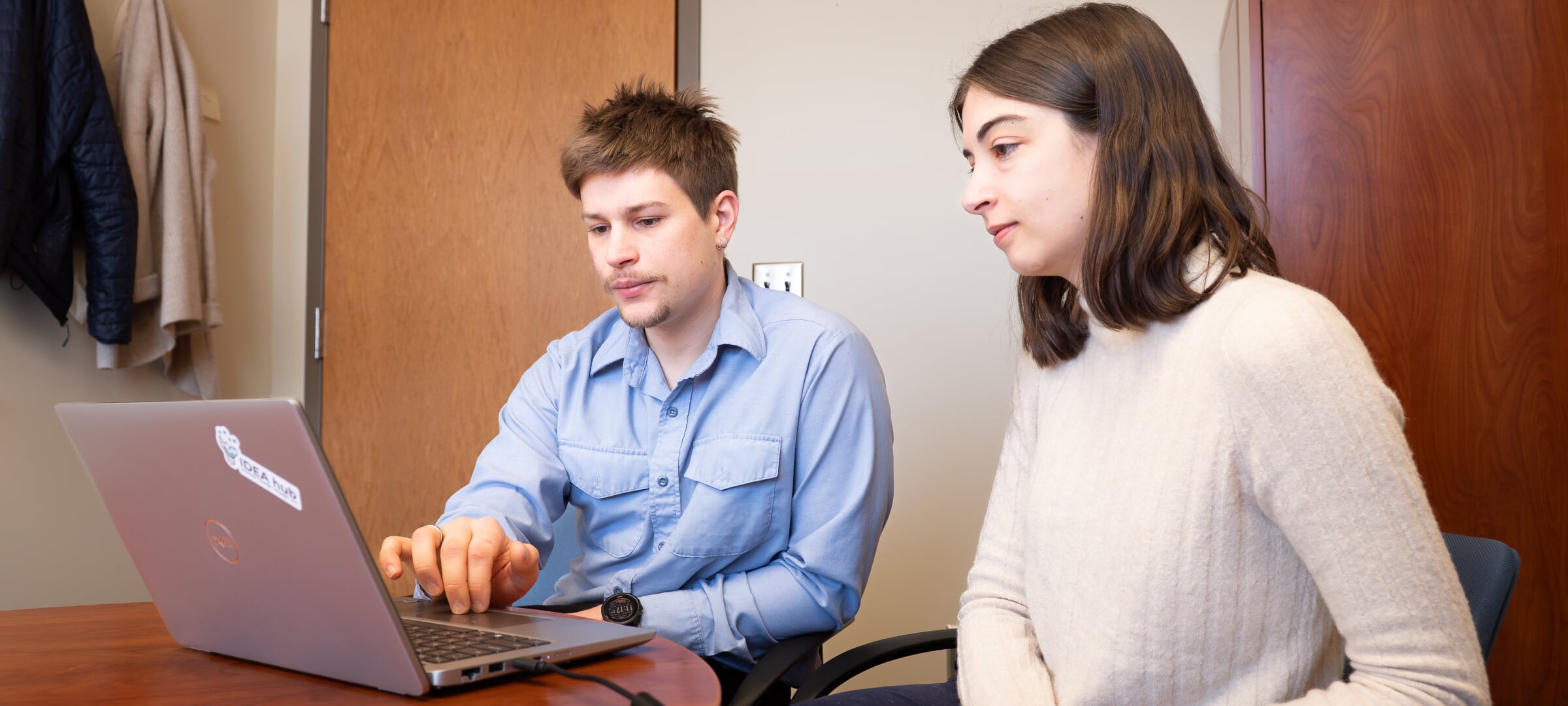 Two students looking at a laptop