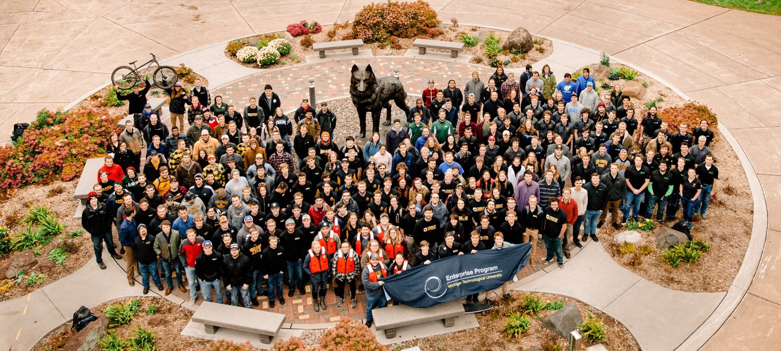 Over 200 current Enterprise students pose near the husky statue