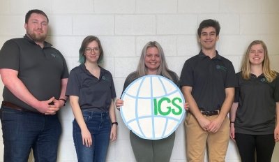 5 team members looking at the camera holding an IGS logo