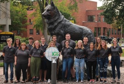 Innovative Global Solutions team members in front of Husky Statue 