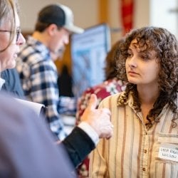 Student looks on as a faculty member is judging the design expo