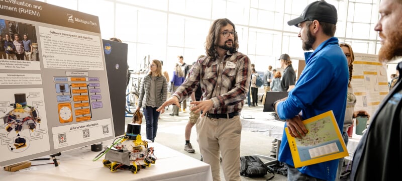 Student discussing their project with a judges during the in-person expo