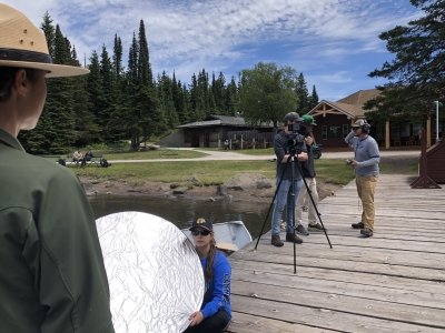 interview of a isle royal staff member with light reflector and camera in view