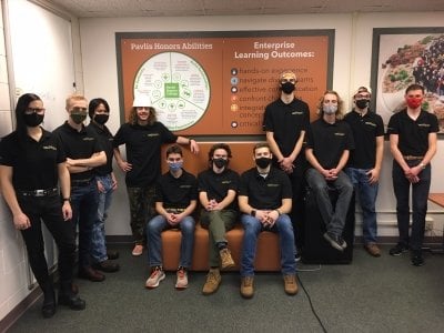 velonations team members standing in front of the Pavlis room information board
