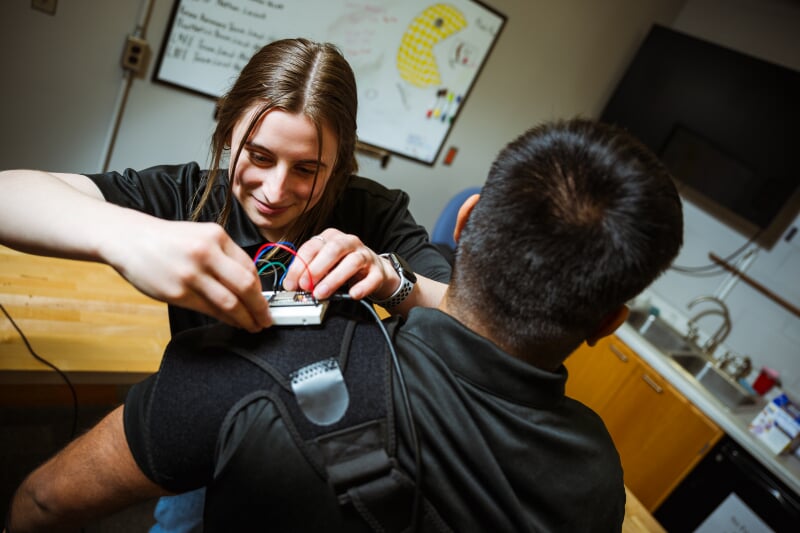 Immy Kniss and Rish Rao mounting a bread board to a shoulder mount to record shoulder joint data.