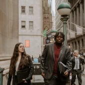 Two students walking out of the subway stairs in New York wearing suits
