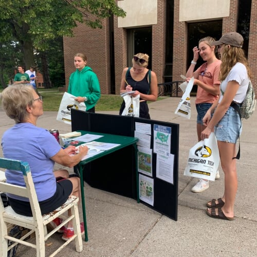 students stopping at a table during a volunteer fair