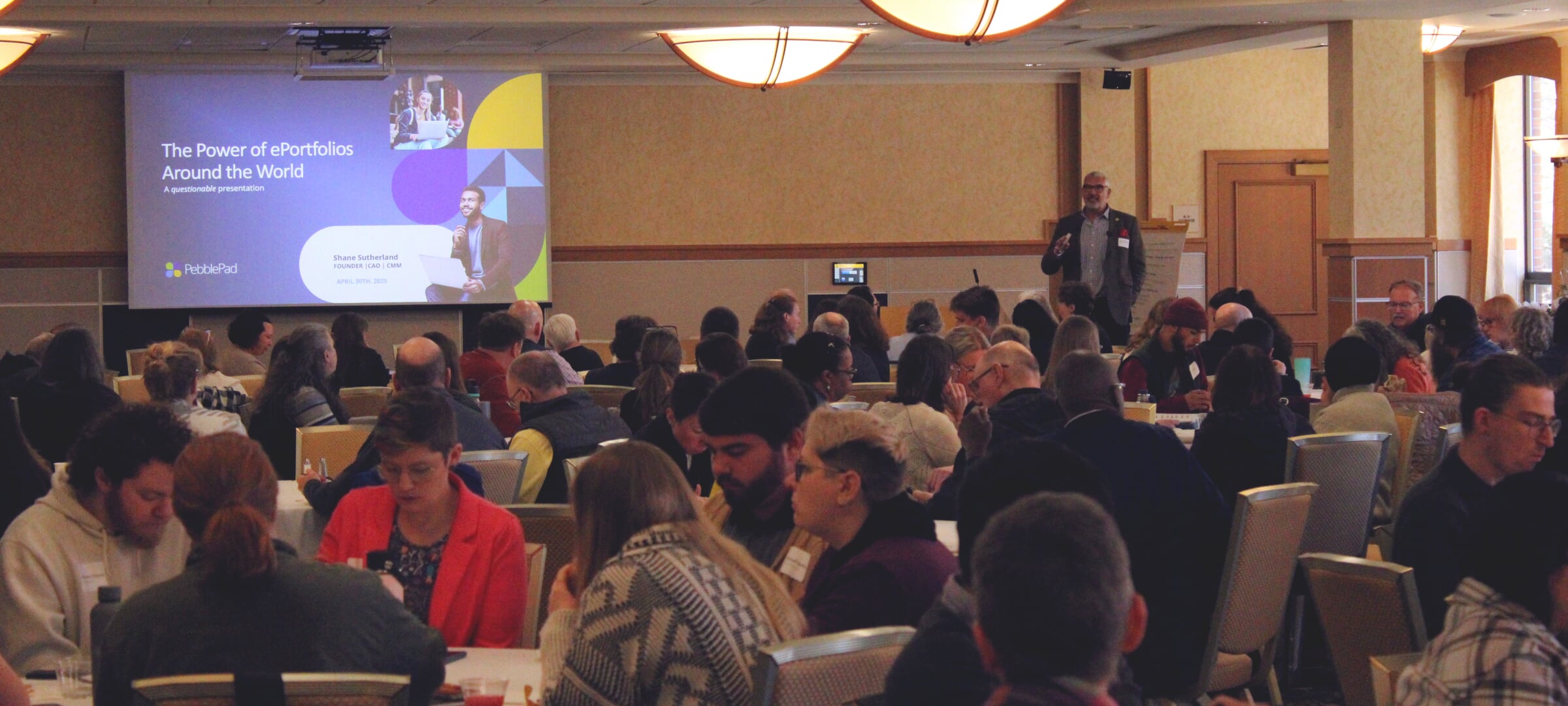 Participants seated at the Essential Ed Symposium listening to the keynote speaker.