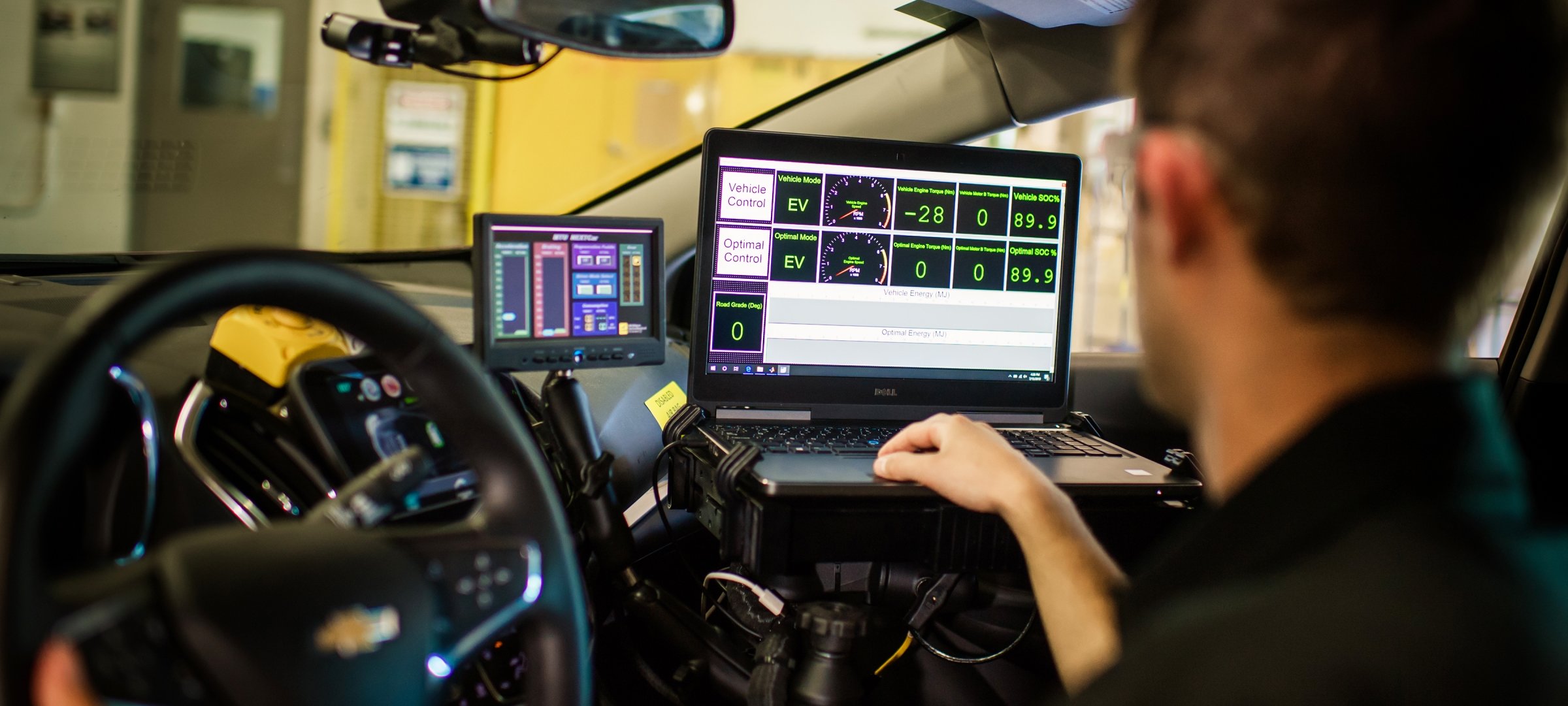 A student inside a car with laptops and monitors