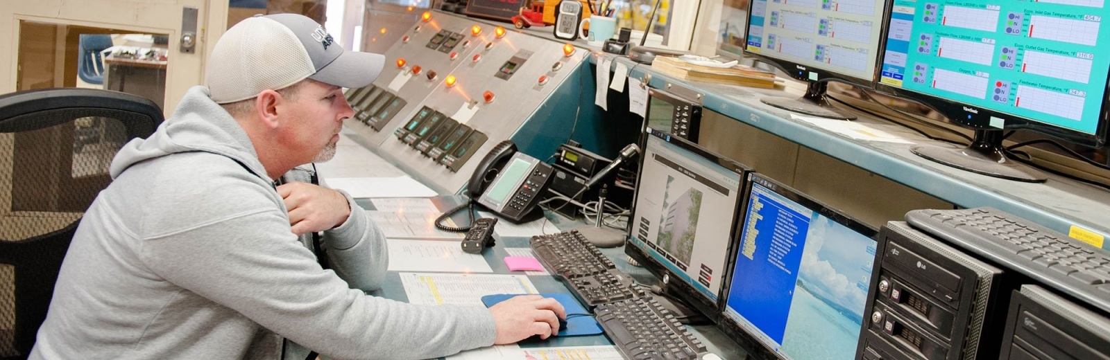 Facilities Management staff member monitoring various system status outputs.