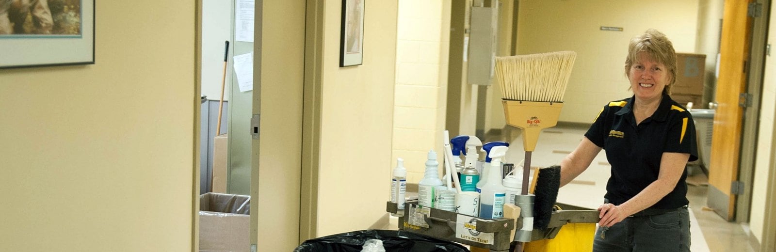 Facilities Maintenance staff member with a cleaning cart.