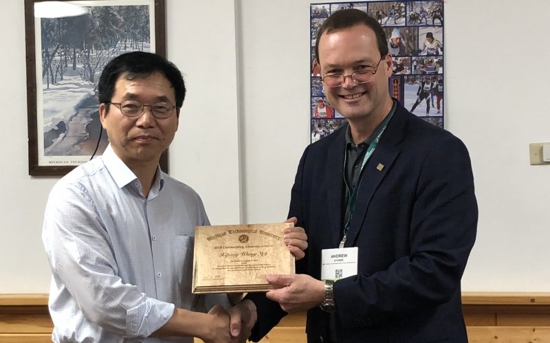 Xiping Wang shaking hands with Dean Andrew Storer