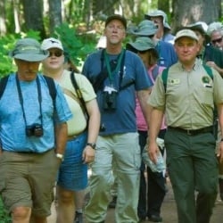 Instructor with a group of K-12 teachers walking on a trail.