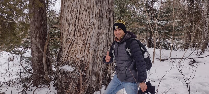 Nate Koetje standing in the woods in the winter.