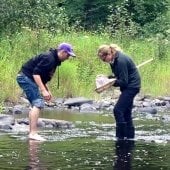 Students standing in a lake taking measurements