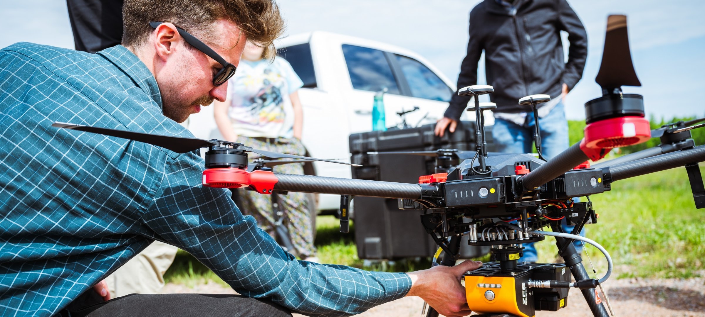 Researchers with a drone in a field.