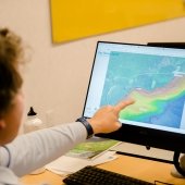 Researcher point to screen with terrain map