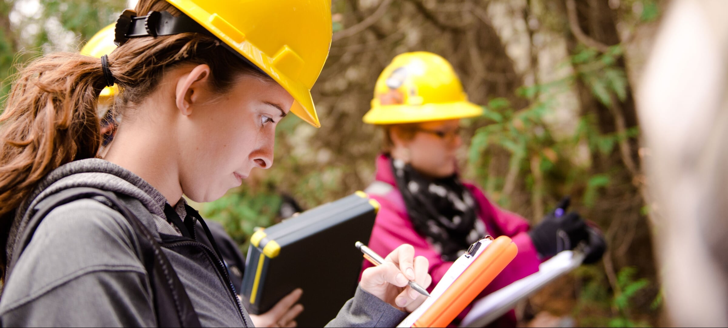 Two students recording information on a clipboard